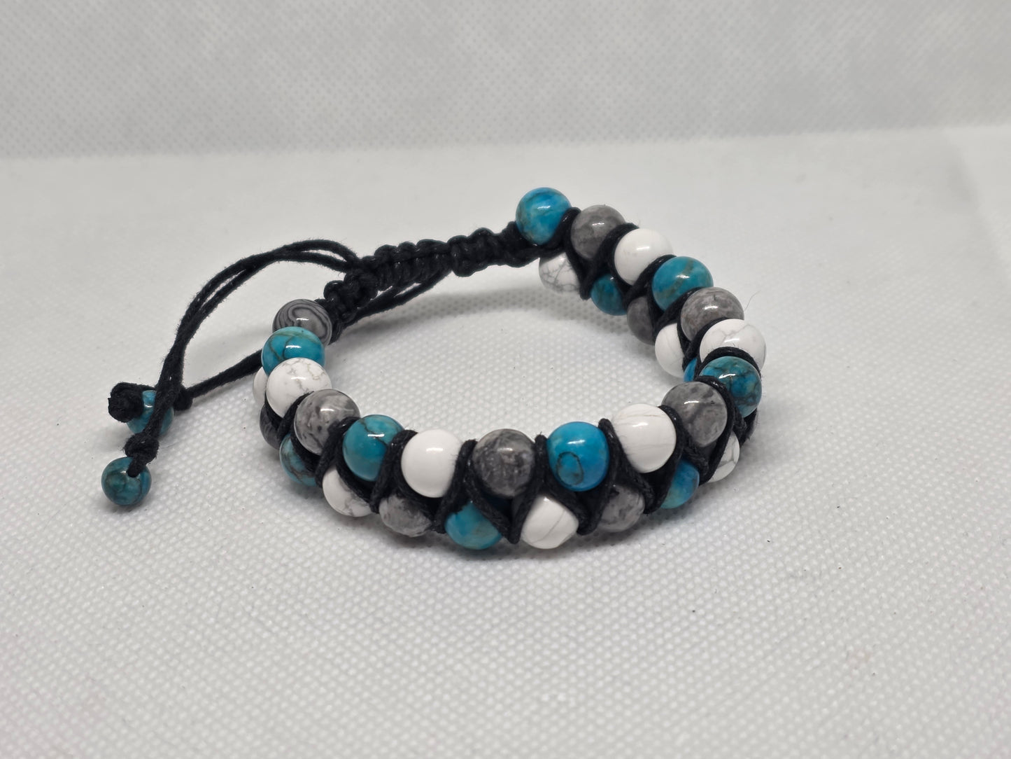 Turquoise, Howlite, and Jasper adjustable bracelet on a white background