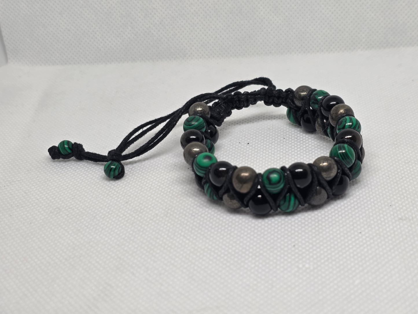 malachite, pyrite and obsidian double strand bracelet on a white background