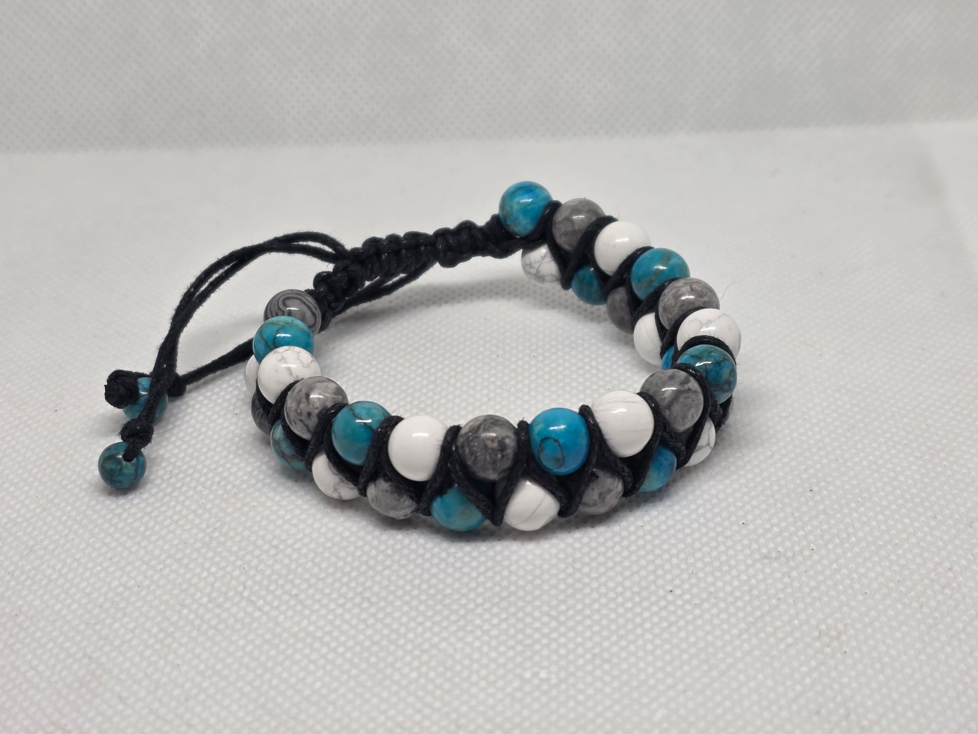 Turquoise, Howlite, and Jasper adjustable bracelet on a white background